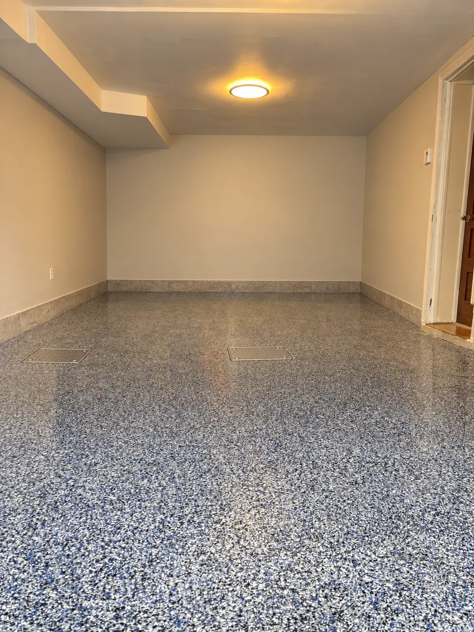 Garage with a glossy blue and grey flake floor, done by Hippoxy